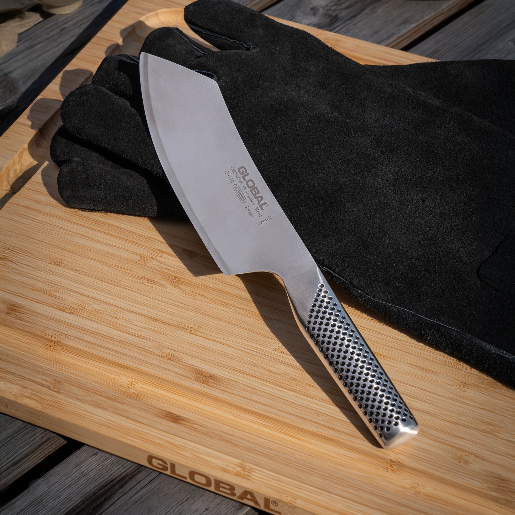 Global 3 Piece BBQ set with BBQ Knife, black gloves on a wooden  bamboo cutting board, featuring the Global brand.