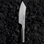 Japanese BBQ Knife by Global on charcoal. Stainless steel barbecue knife with large, curved blade and pointed tip.