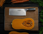Global Chinese chopping knife beside butternut squash on wooden cutting board.