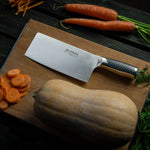 Global Chinese chef knife and whole butternut squash, carrots as chopped carrots on cherry wood chopping board. 