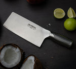 Chinese stainless steel kitchen knife for chopping vegetables, meat, fish and fruit next to chopped lime and coconut.