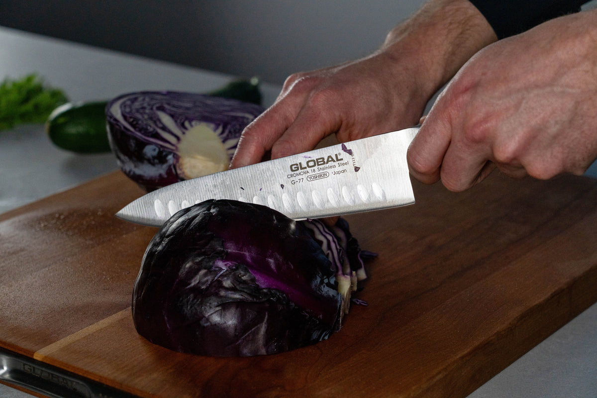 Cook using Global G-77 Fluted Chef's Knife for shredding cabbage. 