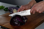 Cook using Global G-77 Fluted Chef's Knife for shredding cabbage. 
