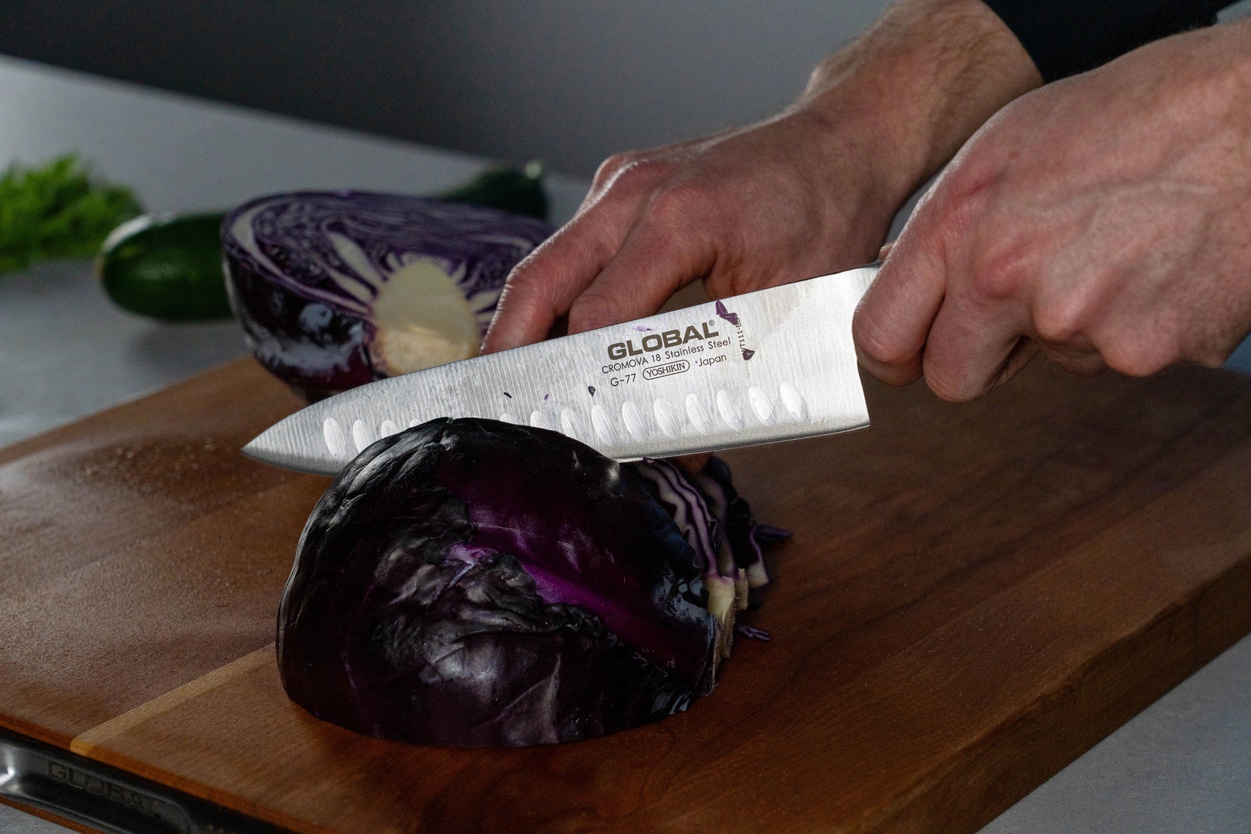Cook using Global G-77 Fluted Chef's Knife for shredding cabbage. 