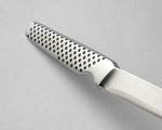 Metallic knife with a textured handle on a gray background, the GSF-15 petty knife.