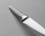 Close-up of the GSF-22 knife blade with a textured handle on a grey background. Shows one piece construction for an easy clean kitchen knife that is hygienic. All stainless steel utility knife.