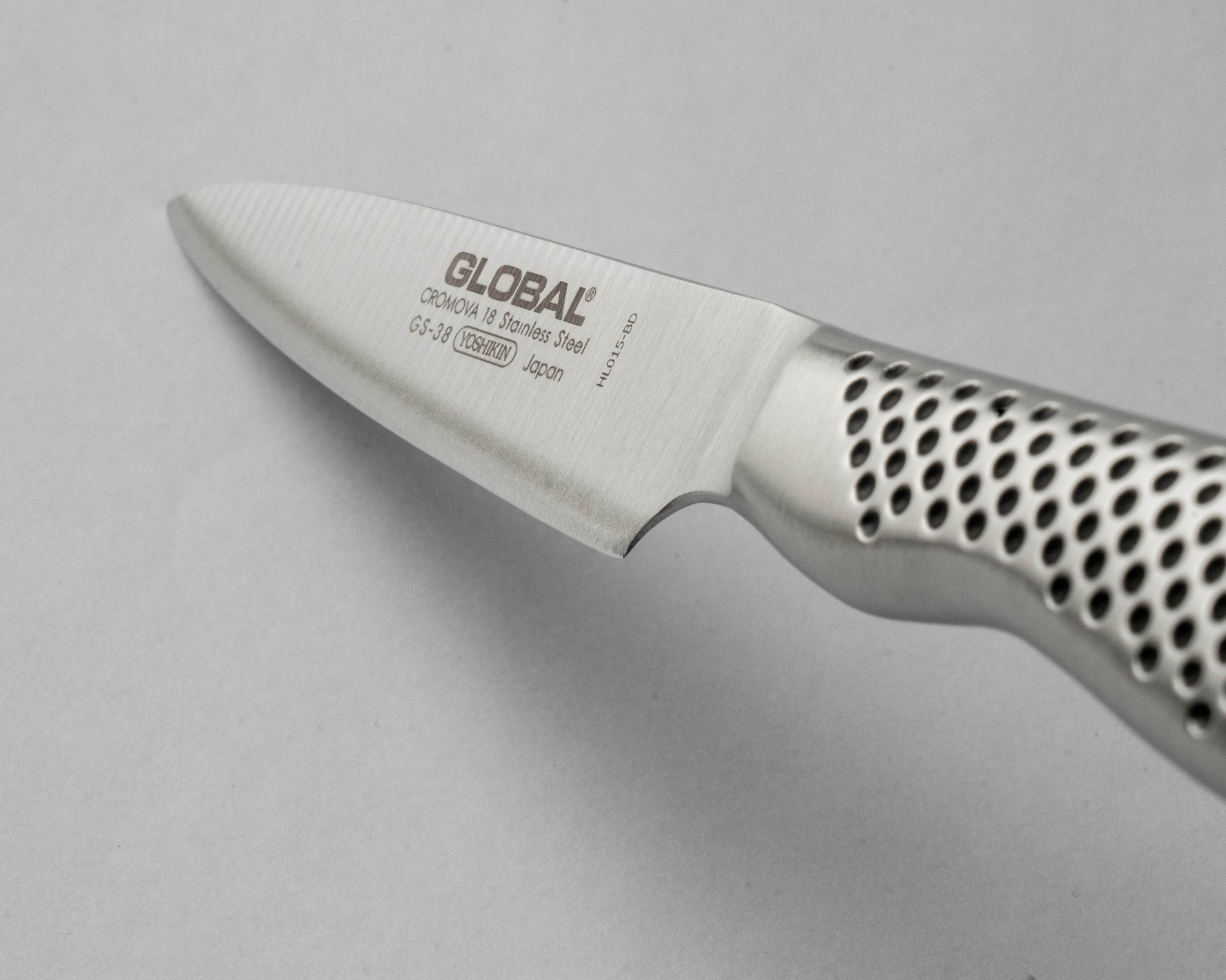 Close-up of a Global small utility knife on a gray background