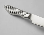 Close-up of a global paring knife handle with a textured pattern on a gray background