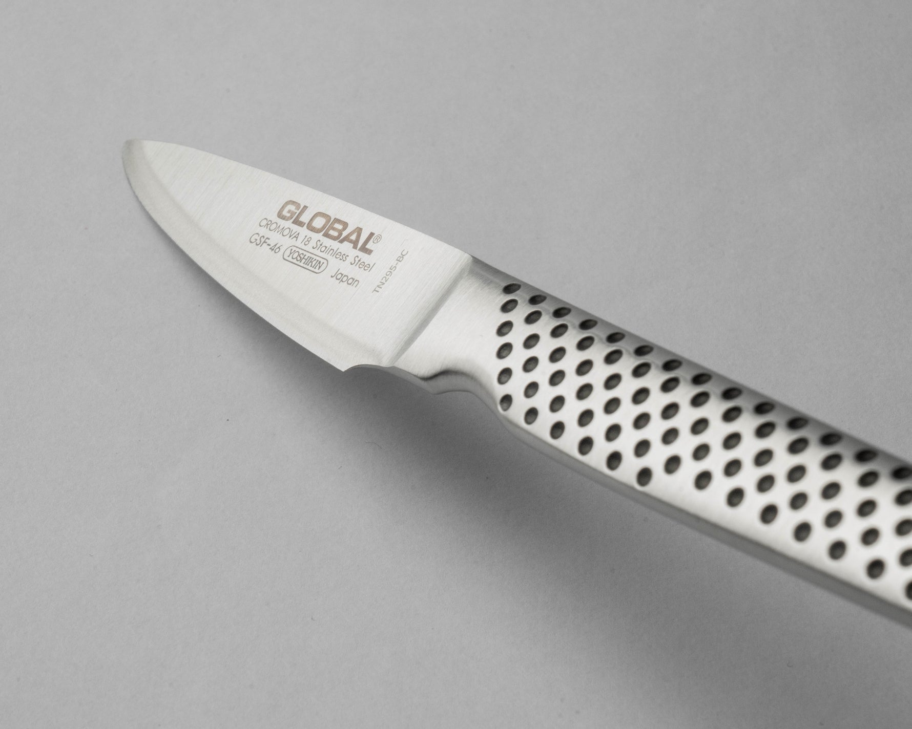 Close up of GSF-46 Peeling Knife with ultra sharp blade on a grey background