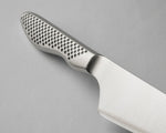 A close-up of the GS-89 Chef's Knife's Cromova 18 stainless steel handle, showing the perforated textured handle set against a solid grey background.