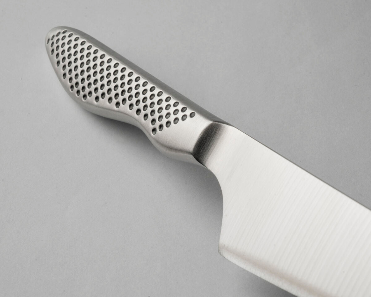 A close-up of the GS-89 Chef's Knife's Cromova 18 stainless steel handle, showing the perforated textured handle set against a solid grey background.