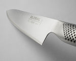 Close-up of a Global G-2 chef's knife blade on a light grey background. Global G-2 Cook's knife's ultra sharp blade with 15 degree cutting edge with global branding made form Cromova 18 stainless steel.