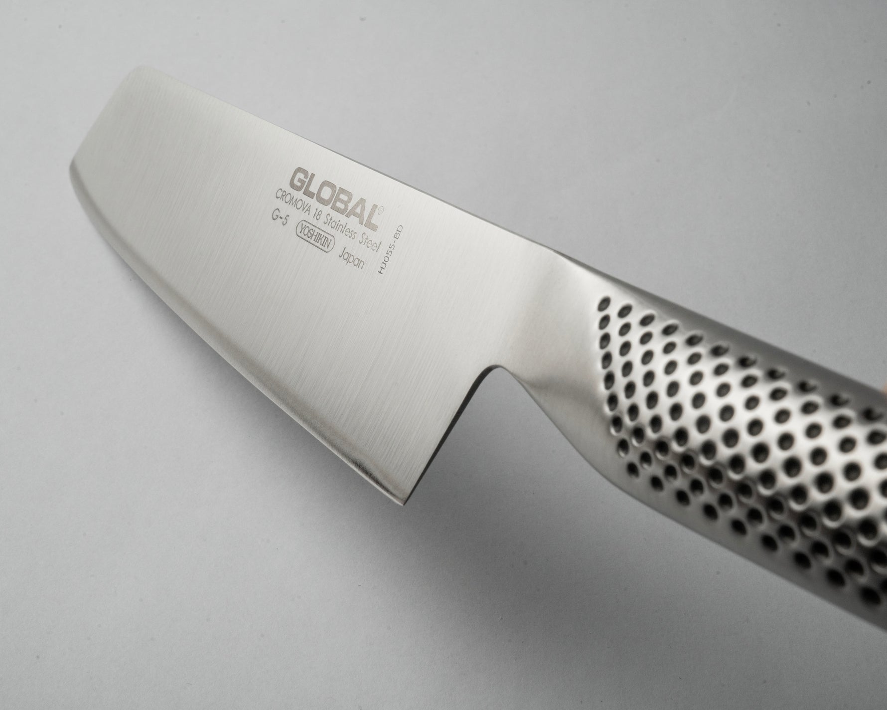 Close-up of a Global brand knife  ultra sharp blade on a light grey background