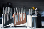 Set of global knives in a wooden block and magnetic knife holder on a kitchen counter. 4 Global knife blocks from the Global Elements collection with stainless steel kitchen knives.