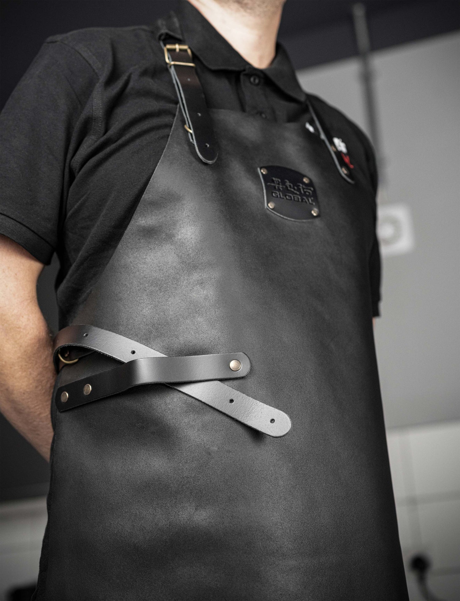 Professional chef wearing black leather Global apron for kitchen use and food preparation