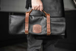 Cook holding Global leather knife bag for compact kitchen knife storage with matching genuine leather apron for cooking, bbqs and grilling.