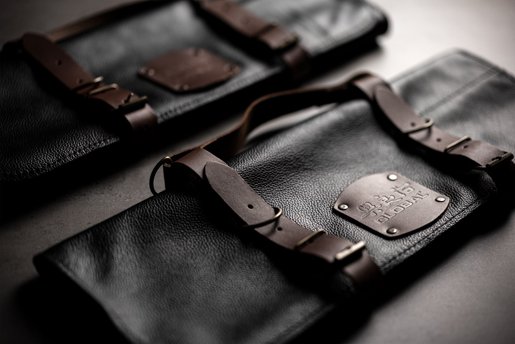 2 black leather knife roll cases with 5-slot and 10-slot capacity