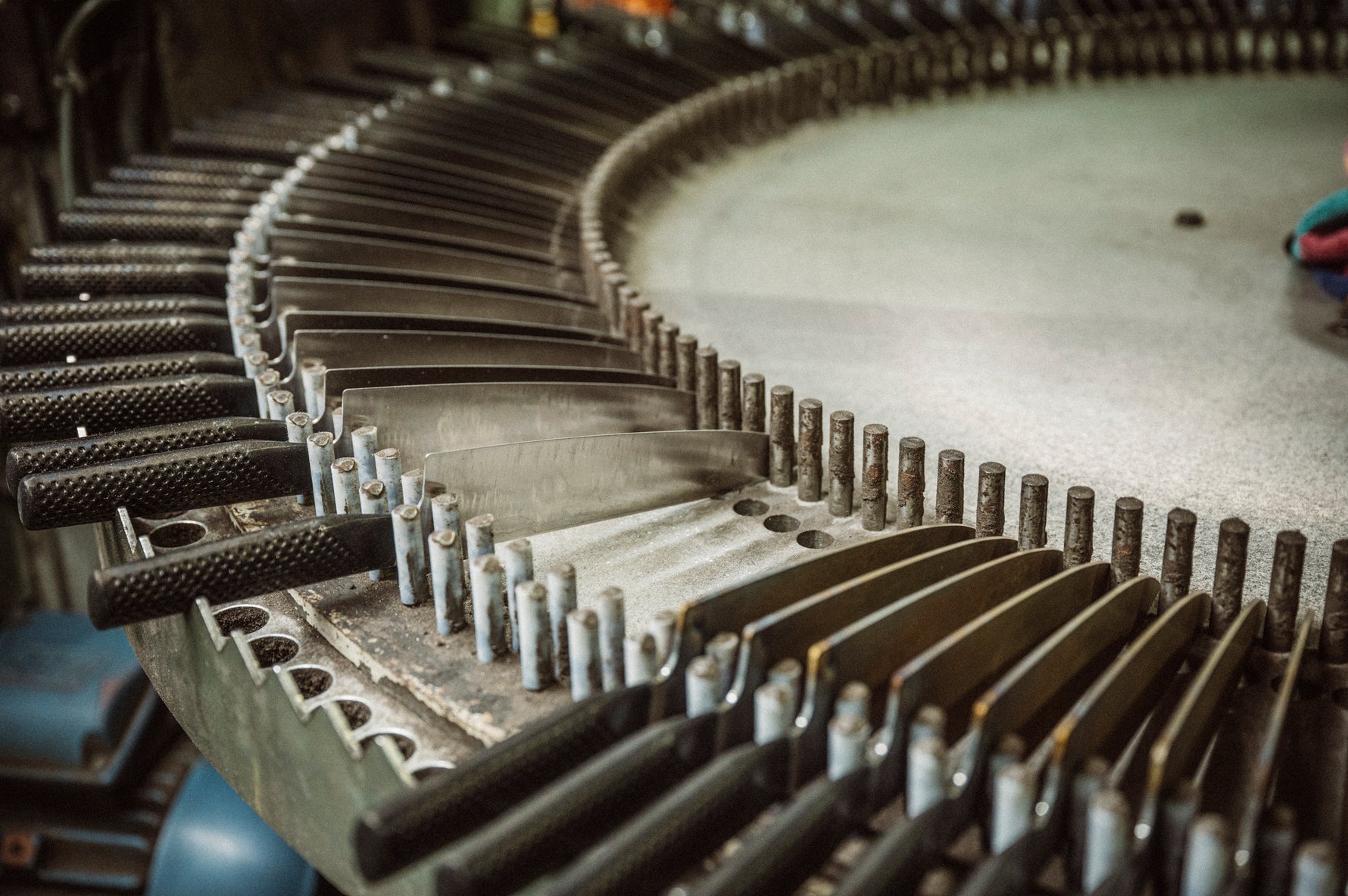 Close-up of a mechanical gear system containing lots of Global knives.