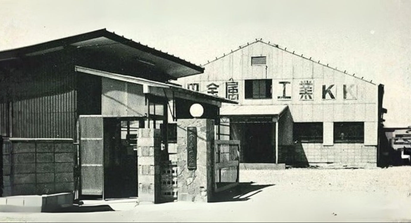 Vintage photograph of Yoshikin industrial buildings with a prominent sign on the right.